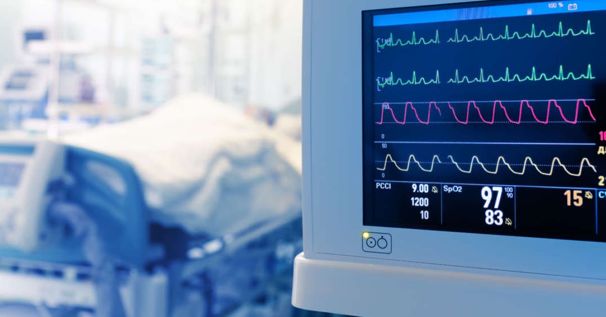 patient in hospital bed near monitor