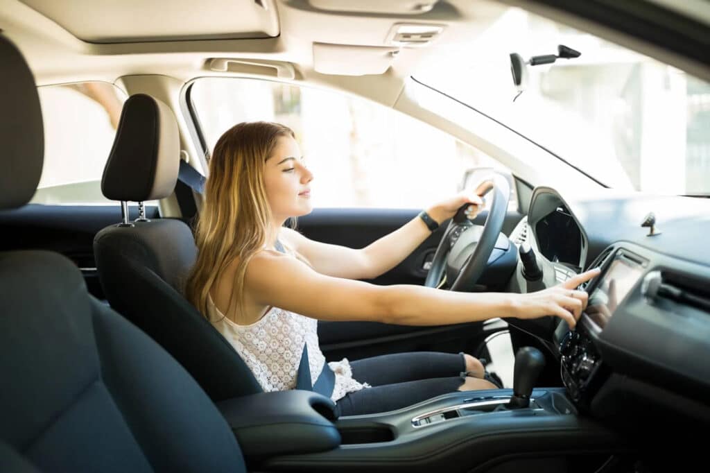Distracted Driving woman using in-dash screen while drving