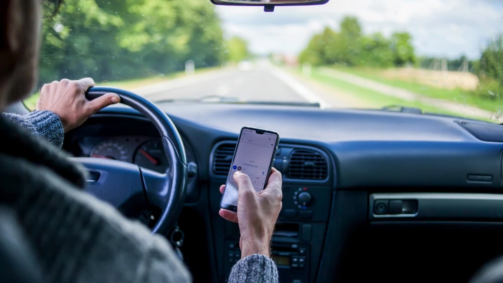 man texting and driving