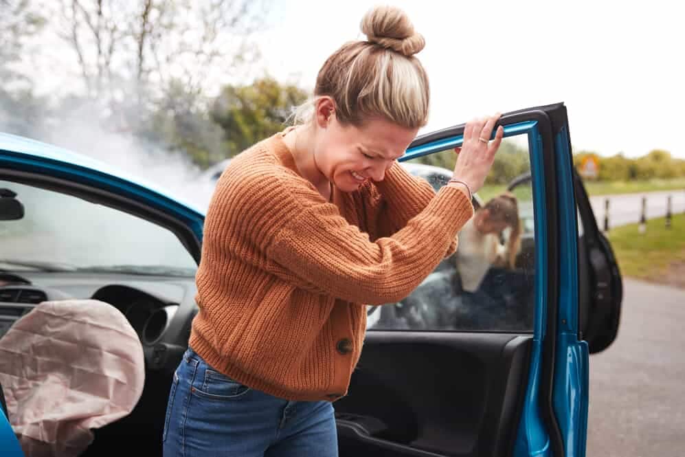 woman wincing in pain after auto accident