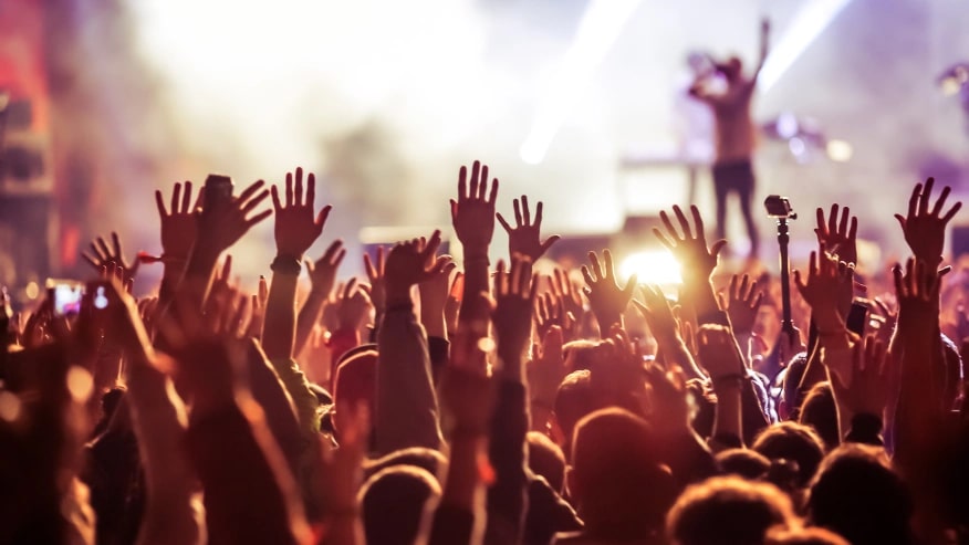 crowd at concert with hands up in the air