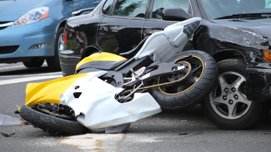 motorcycle leaning against car after accident
