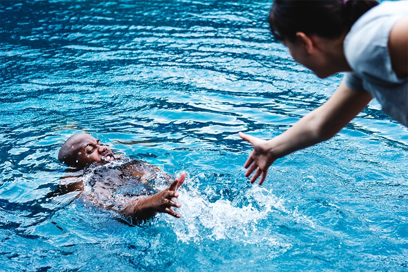 person reaching out to save drowning person