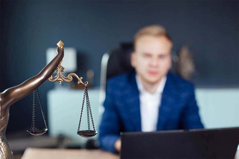 photo of motorcycle accident lawyer (blurry) and scales of justice (clear)
