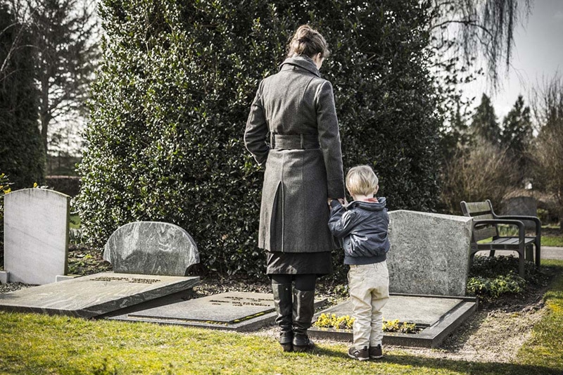 woman and boy standing in graveyard