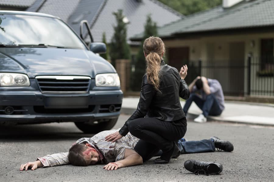 man lying on the ground after a car hit him when he was walking