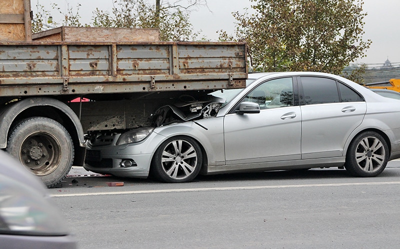 grey car rear-ending a truck