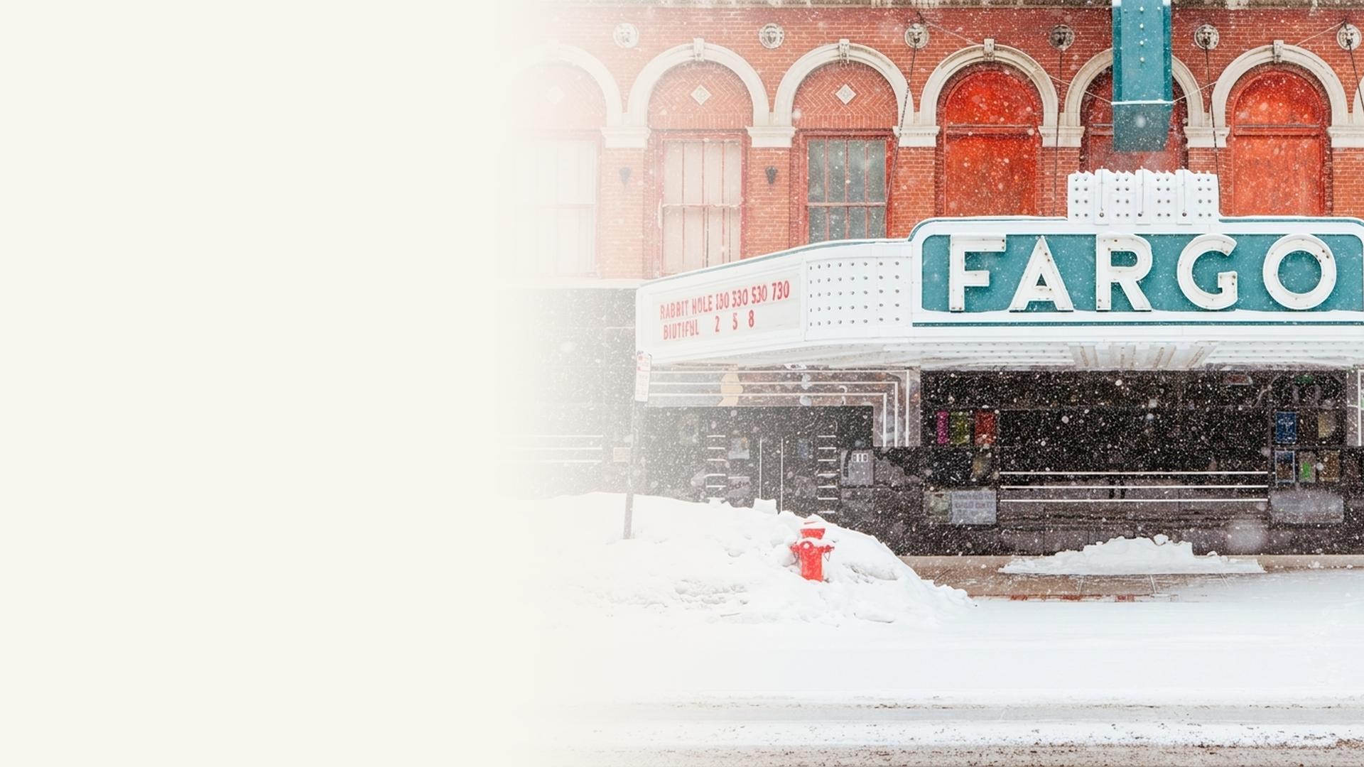 The historic Fargo Theatre marquee during a winter snowfall in downtown Fargo, North Dakota