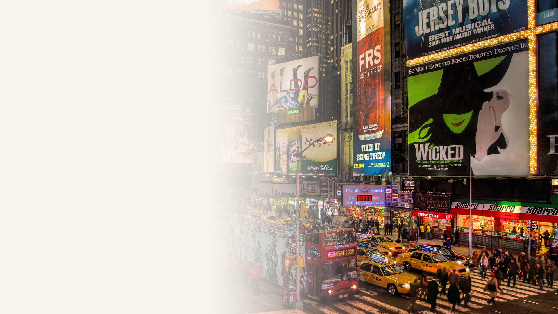 Times Square at night in New York City with Broadway theatre billboards, yellow taxis, and crowds on the street