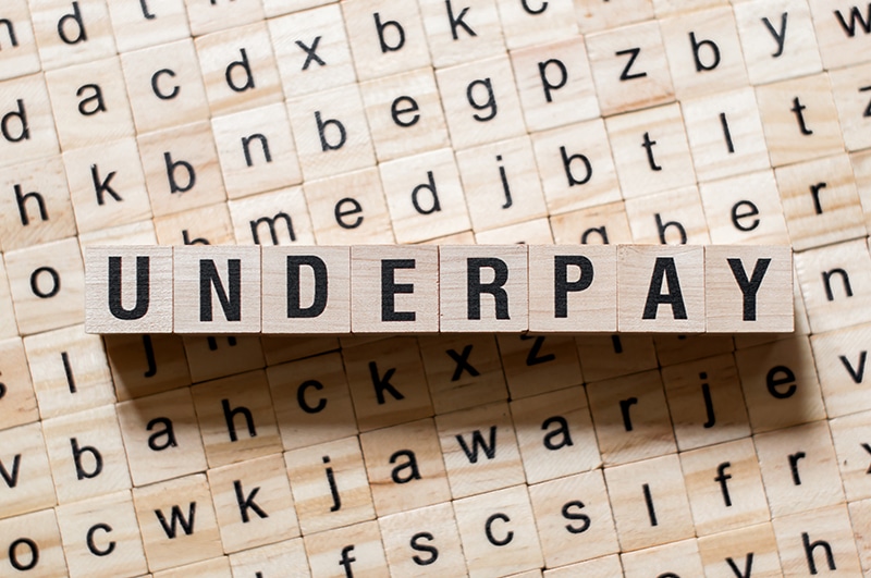 Insurance adjuster reviewing claim paperwork, illustrating how insurers underpay claims