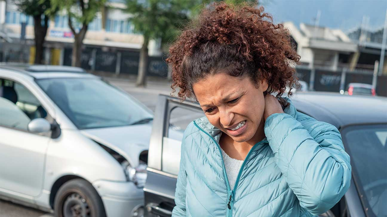 woman grabbing her neck after car accident