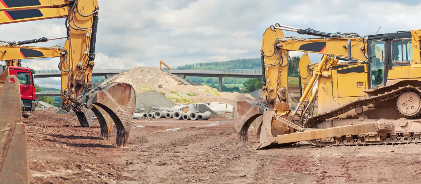 various pieces of construction equipment in front of bridge