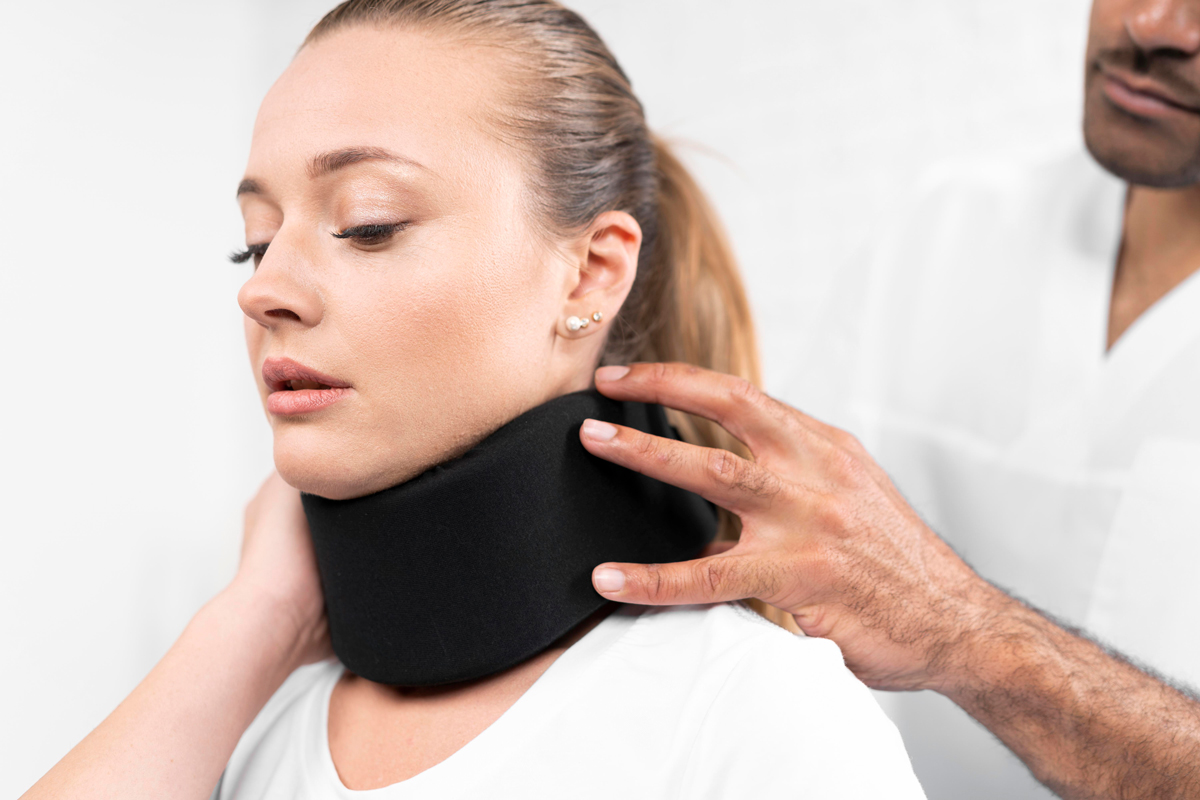 woman getting neck brace adjusted by medical personel