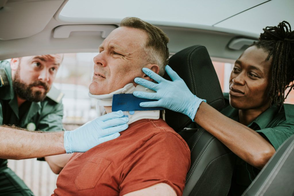 paramedics treating a car accident victim while in the car